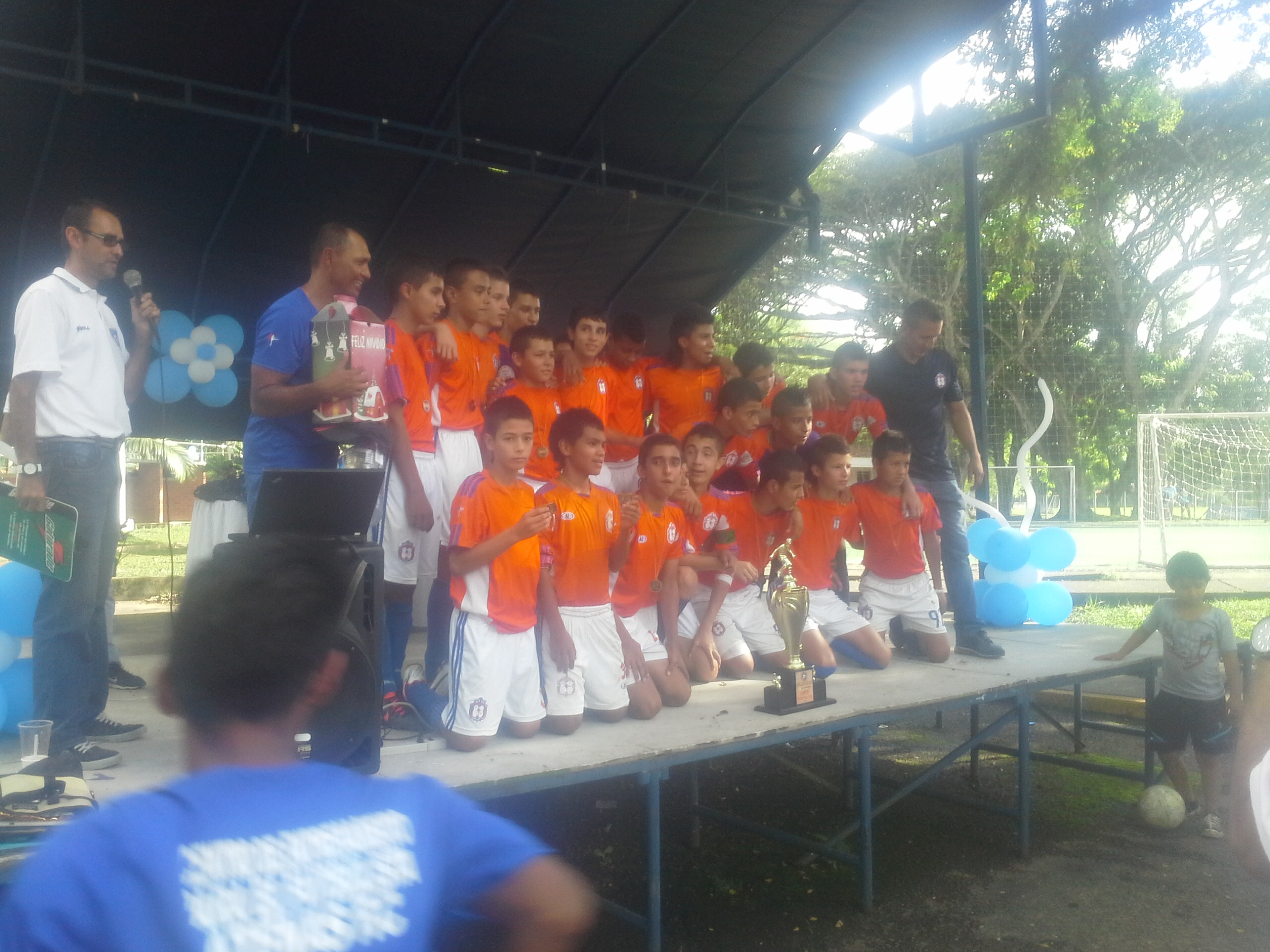 Equipo juvenil con trofeo en presentación